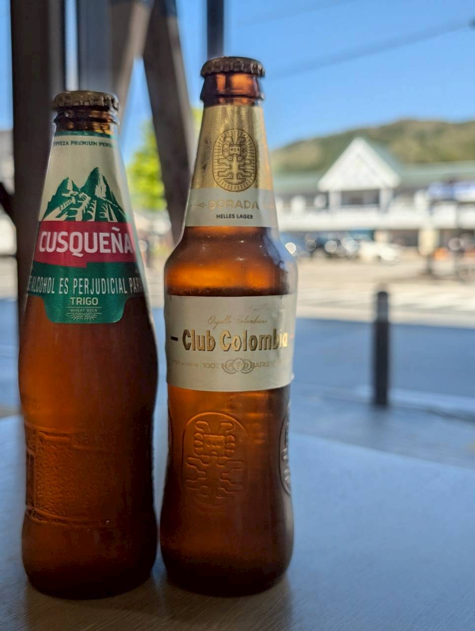 Cusqueña Peruvian wheat beer and a Club Colombia Dorada lager by the window — Focaccino Hakuba