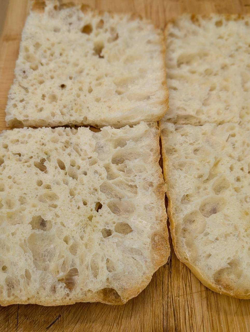 Close-up of the airy, open focaccia crumb cross-section showing the texture of the handmade dough — Focaccino Hakuba