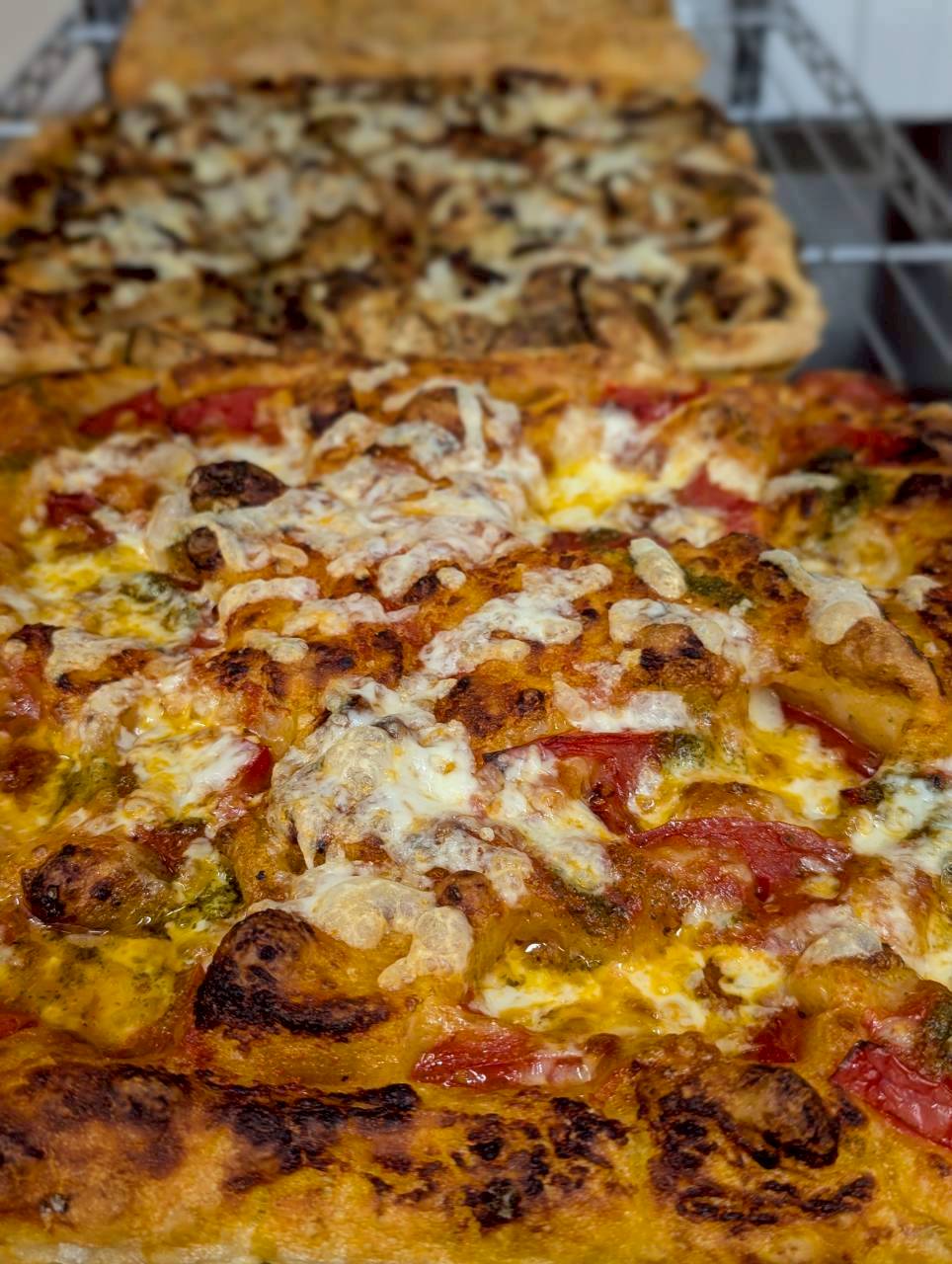 Margherita-style focaccia with fresh tomatoes and melted cheese, golden crust — Focaccino Hakuba Station cafe
